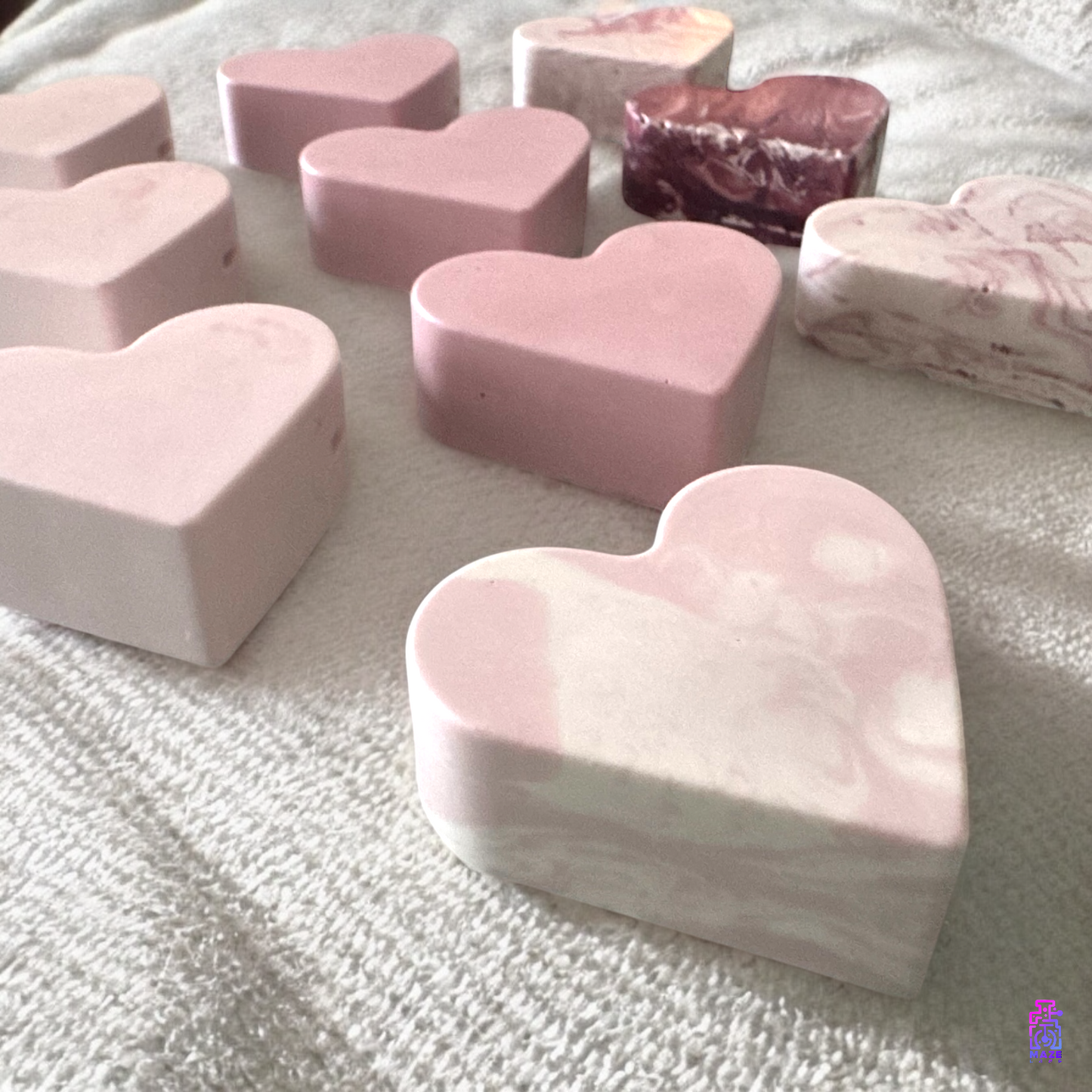 Side view of multiple KALB heart-shaped photo holders, highlighting their smooth surfaces and compact design.