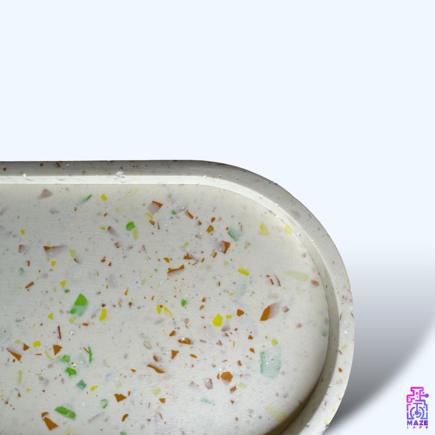 Close-up of OVU oval tray in terrazzo jesmonite, highlighting its unique embedded stone chips and smooth handcrafted finish.