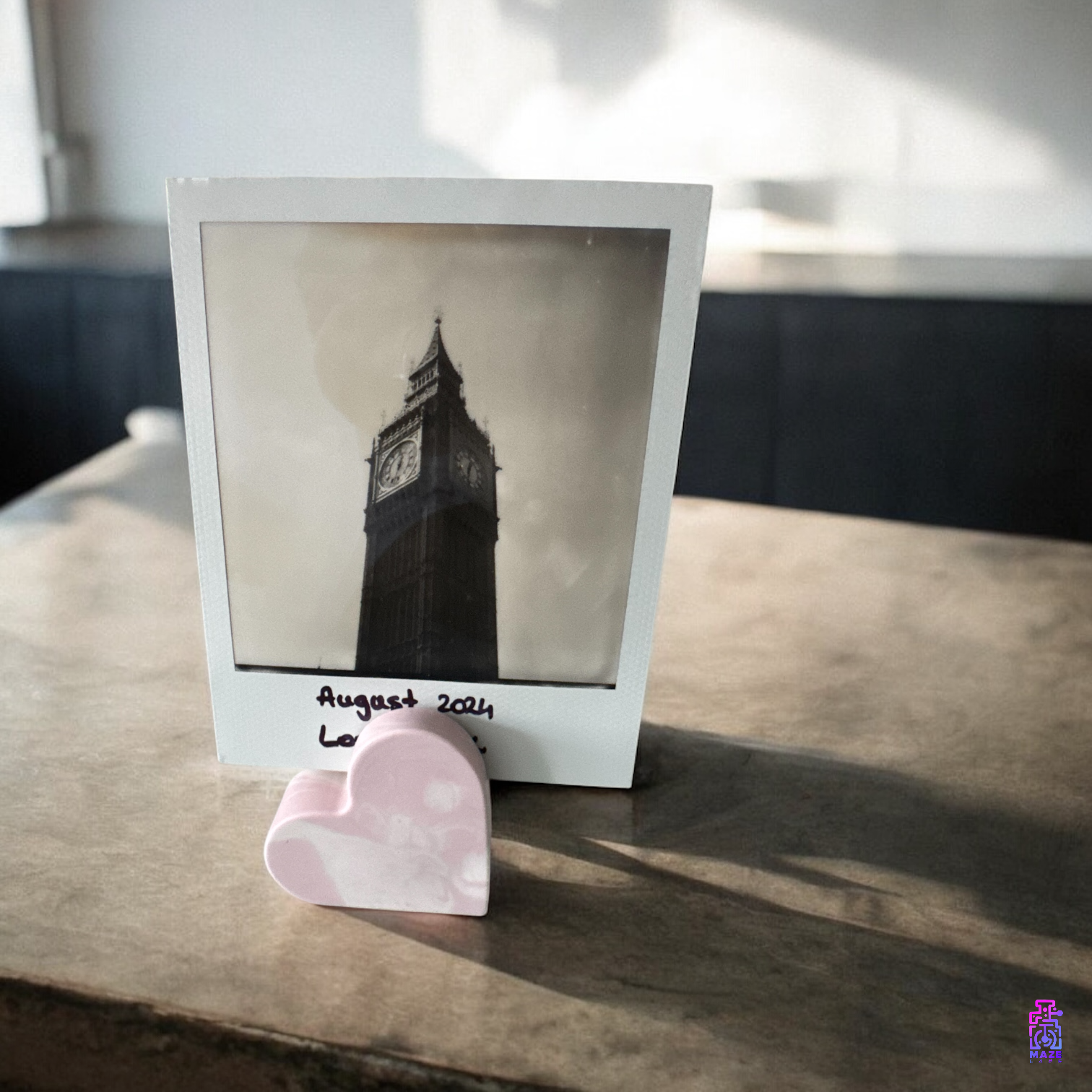 KALB heart-shaped photo holder placed on a countertop, holding a photo upright in a natural setting.