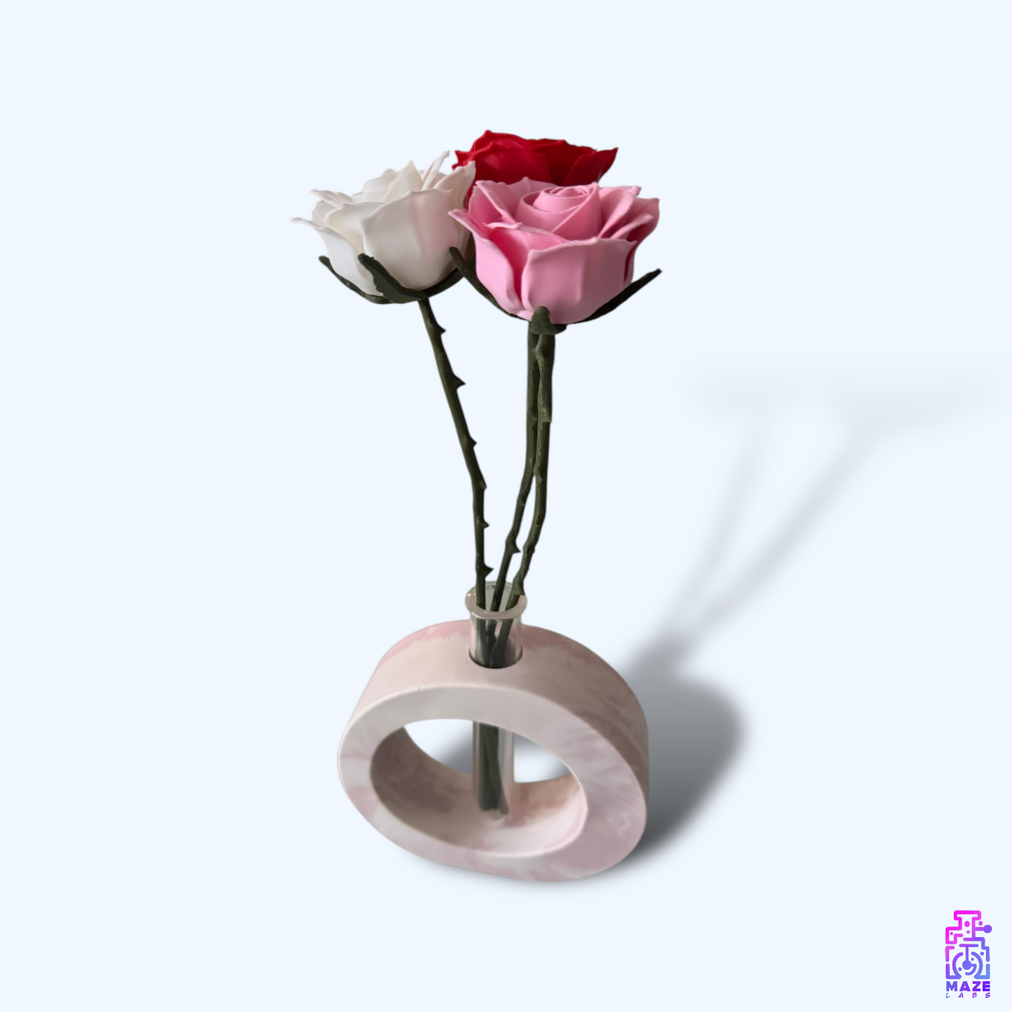 OHM vase in soft pink jesmonite, featuring a circular form with inserted flowers in the plastic tube.
