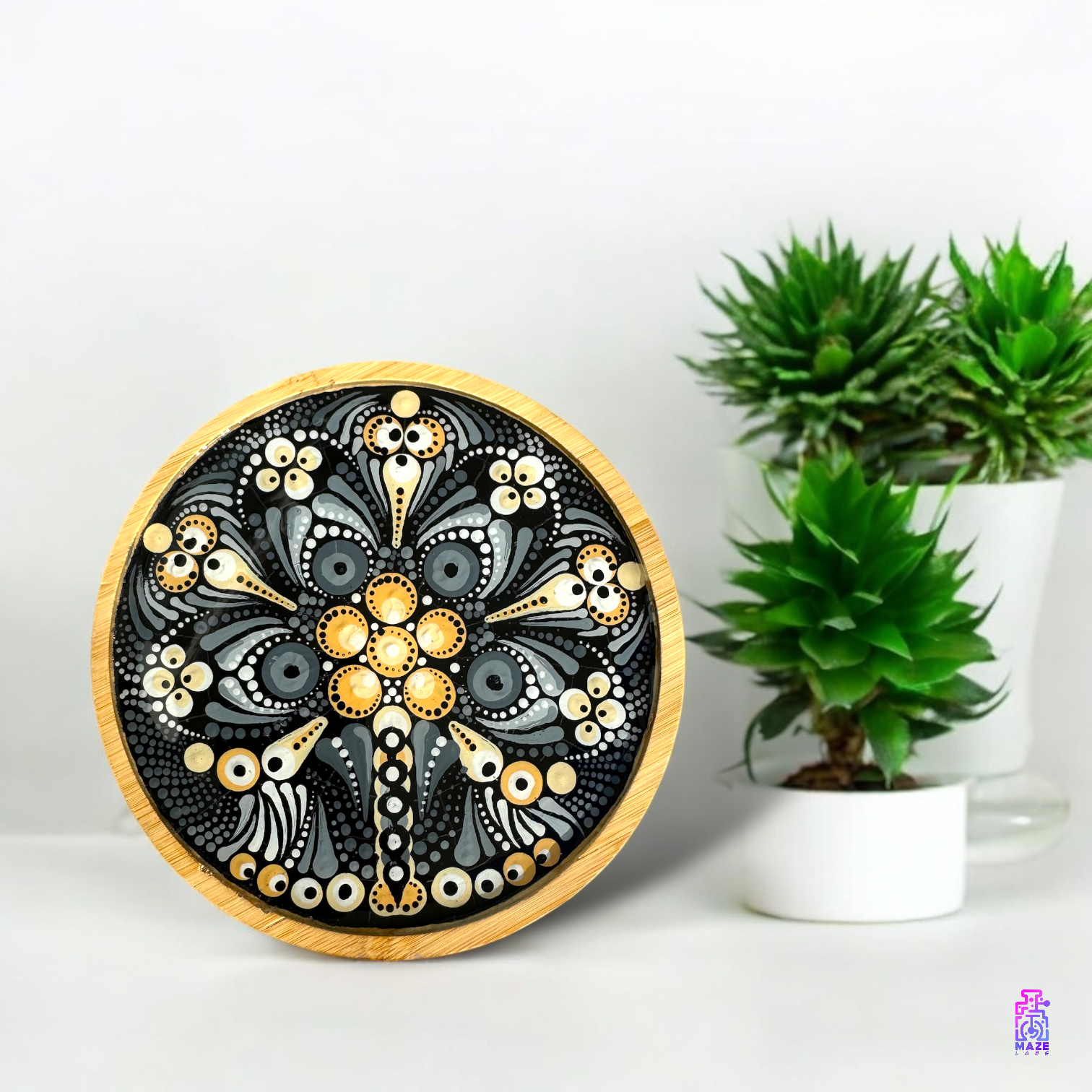 ROOT wooden tray with a black and light brown mandala design, placed on a countertop next to green plants for a natural aesthetic.